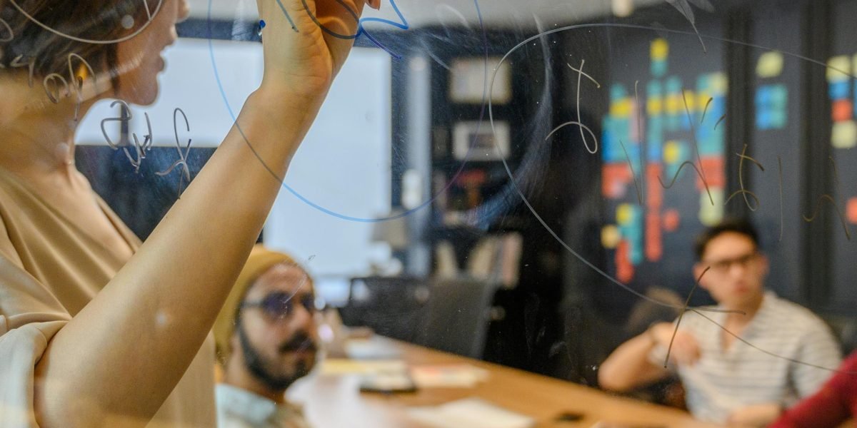 A person leading a strategic planning session at a whiteboard, symbolizing the data analyst's role in guiding business decisions with AI.