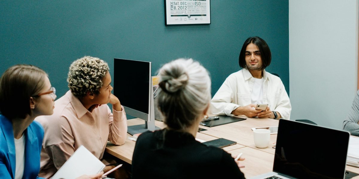 A diverse group of professionals engaged in a thoughtful discussion about the ethical implications of new technologies.