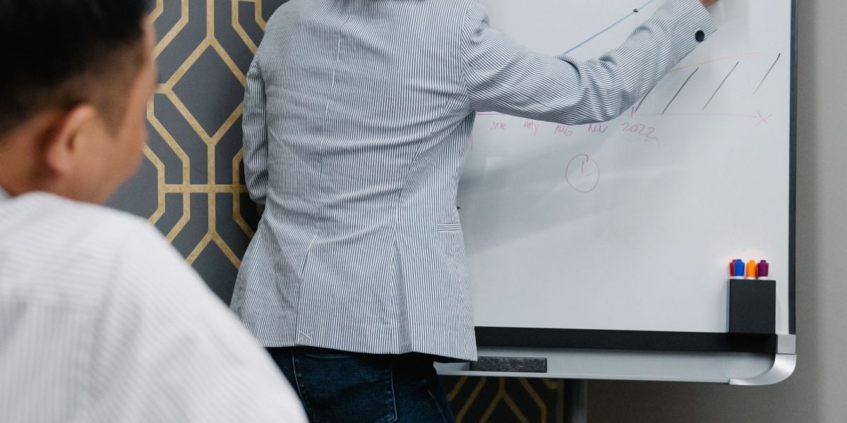 A team actively collaborating and mapping out their strategy on a whiteboard, reflecting integration of technology components.