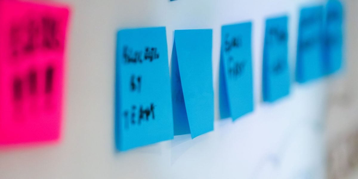 A group of individuals actively brainstorming ideas on a whiteboard, tackling complex challenges.