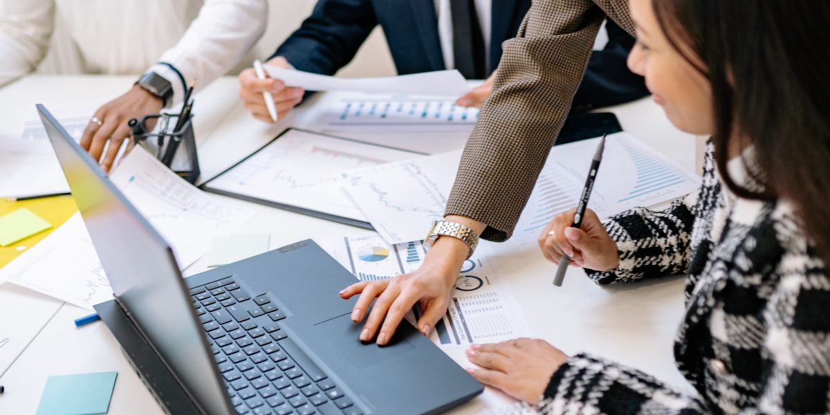 A team of business professionals discussing and comparing various AI voice platforms, making strategic decisions for their company's needs.