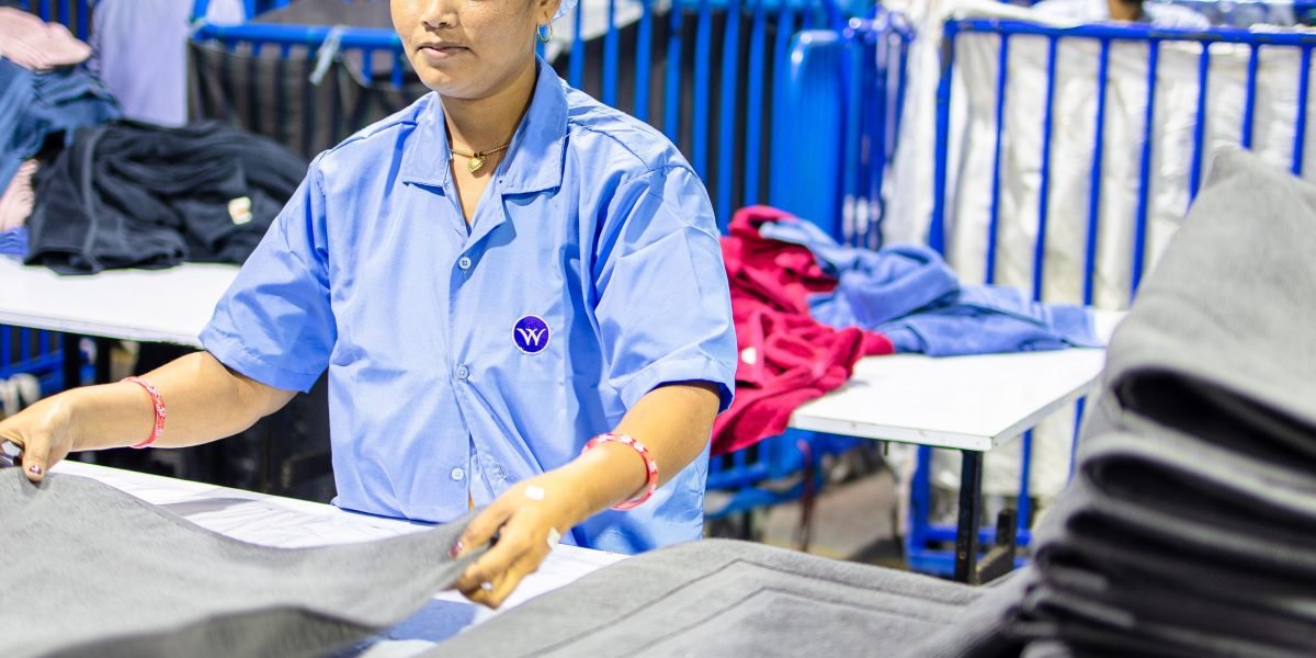 A factory manager in safety gear observing the production line, ensuring efficiency and quality.