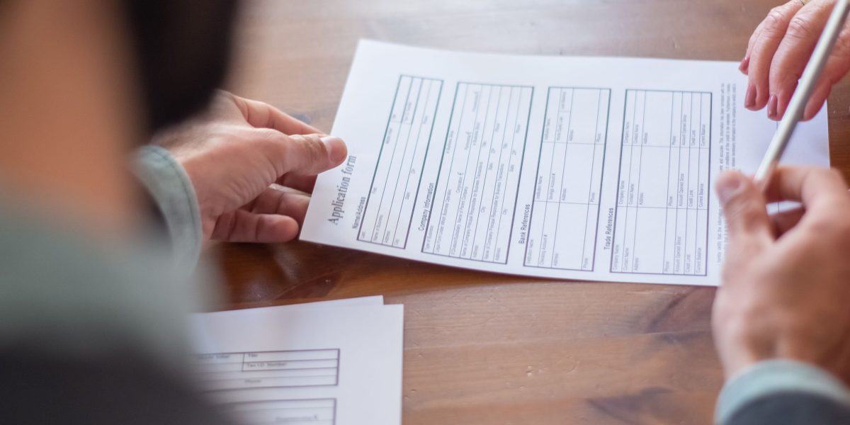 Business professionals meticulously review a contract, ensuring all terms and conditions are clearly understood.