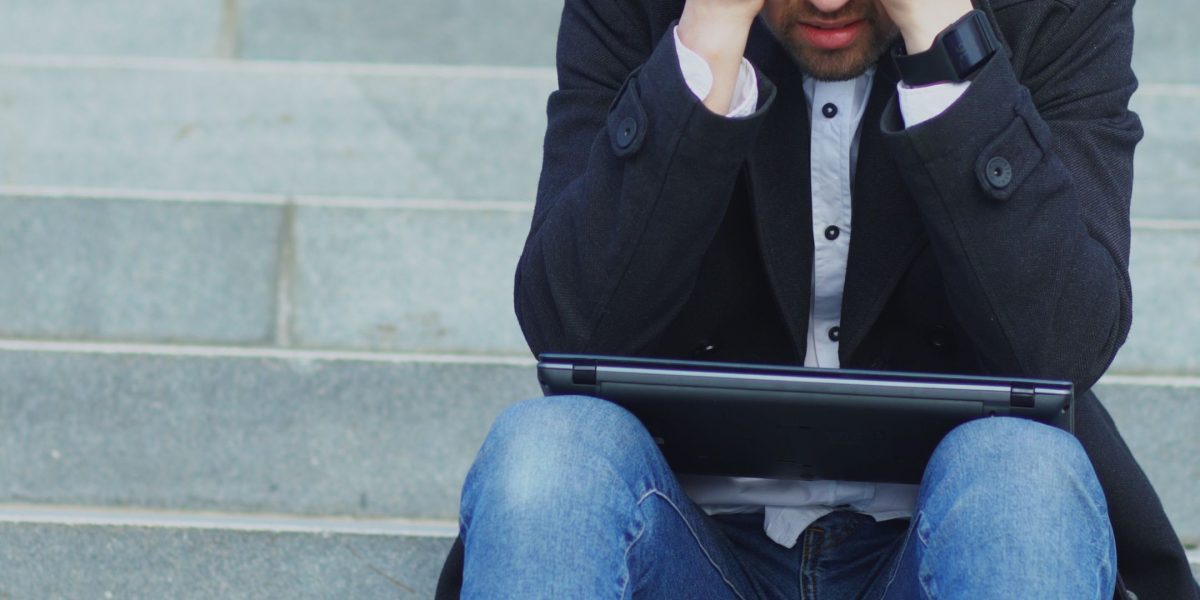 A person looking at multiple screens or documents, conveying a sense of being overwhelmed by too much information.
