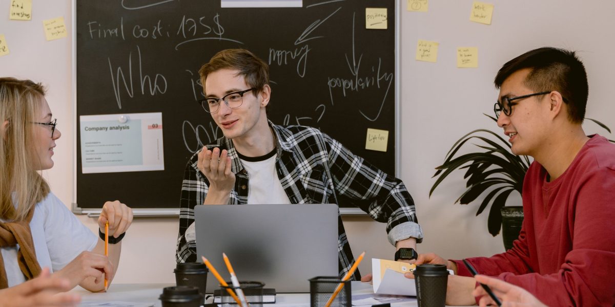 A group of professionals in an office setting, actively collaborating and discussing product development, reflecting the journey from research to reliable products.