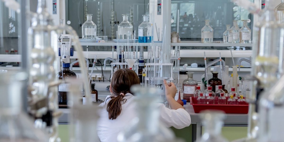 A team of students works together on a whiteboard, brainstorming and solving complex problems in a lab setting.