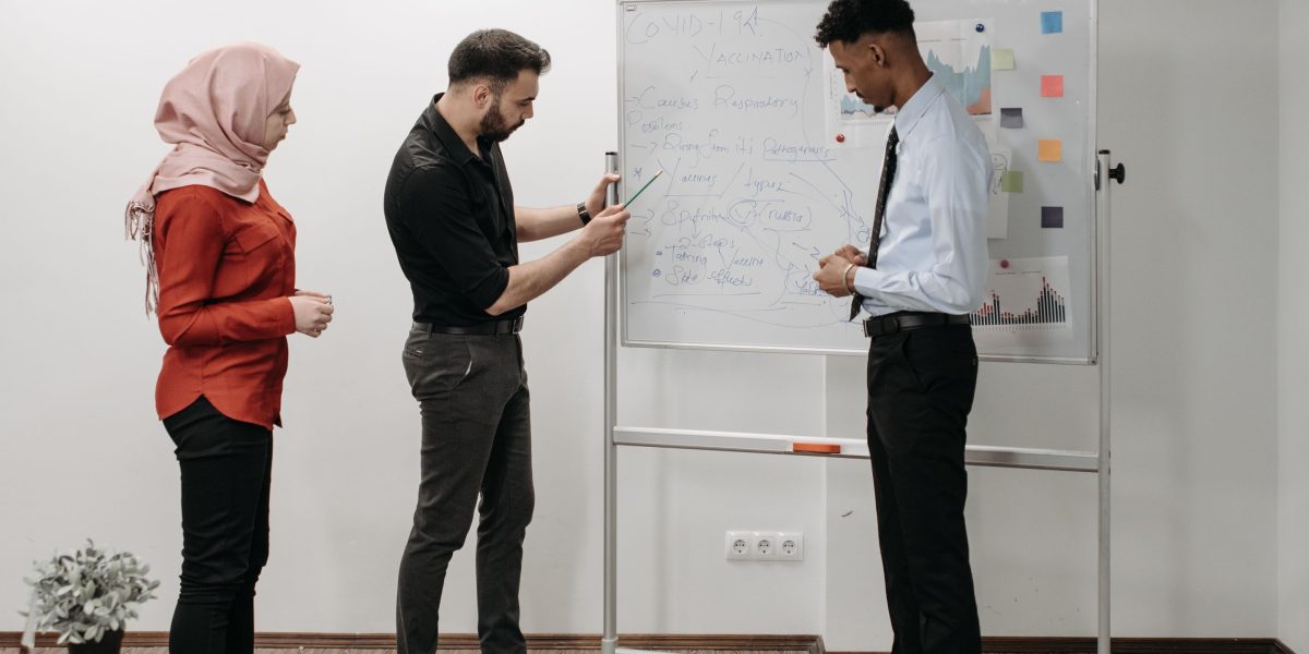 A diverse team collaborating around a whiteboard, actively strategizing for future workforce needs and AI integration.
