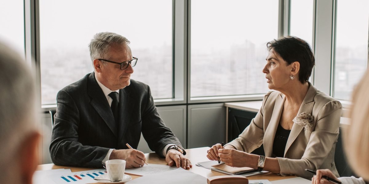 A group of professionals in a business meeting, engaged in a discussion about investment strategies and company growth.