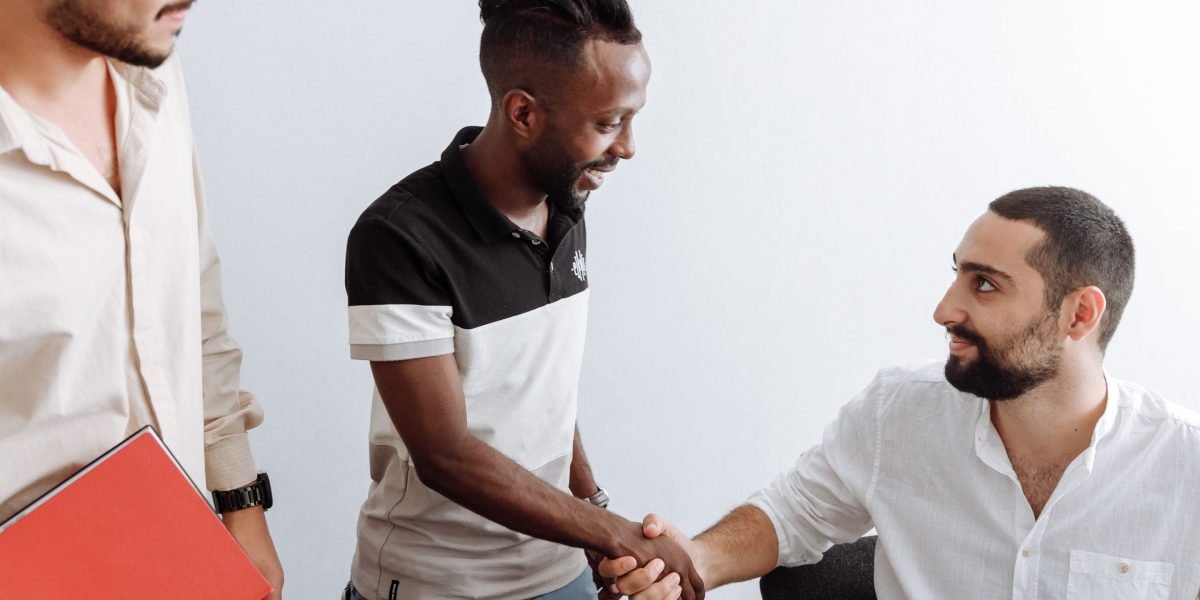 Two professionals shaking hands, signaling a successful interaction, representing the impact of skills and verified credentials in employment.