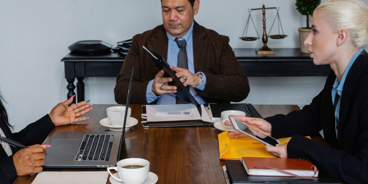 Professionals engage in a focused discussion over legal documents, emphasizing the importance of compliance and IP in tech exchange setup.